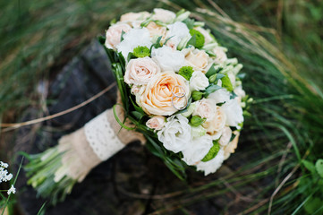 Close-up photo of wedding bouquet made of roses on the stump.