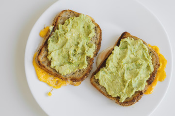 Two hot toasts with whole grain bread, eggs and avocado. Breakfast food. Healthy eating concept