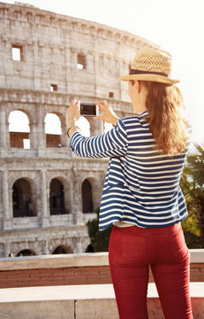 tourist woman in Rome, Italy taking photo with smartphone
