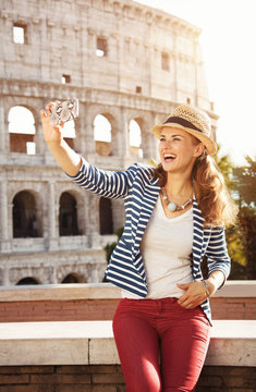 traveller woman in front of Colosseum taking selfie with phone