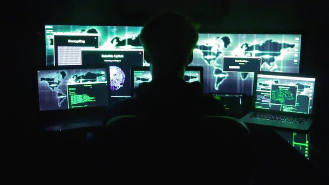 hacker working on multiple screens