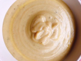 Top view of a cream soup of Zucchini and vegetables in a white bowl