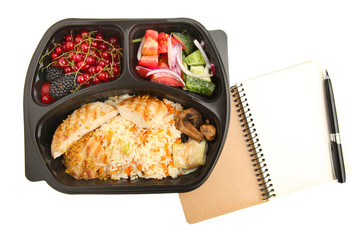 Useful food in container and notebook with pen, isolated on white. Concept of nutrition planning.