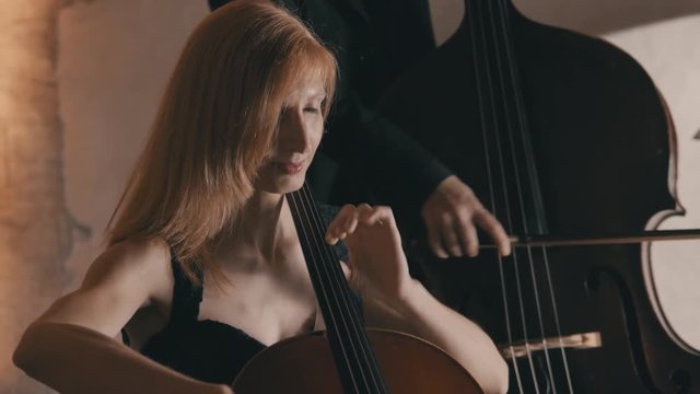 A female cellist plays her cello with passion in a string quartet