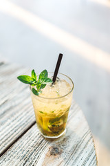 Mojito cocktail on the wooden table at a sunny day