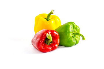 Yellow green and red bell sweet pepper with white background.