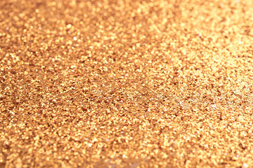 Background of shiny blurred vivid golden colored glitters shimmering calmly