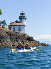 Couple in a sea kayak and lighthouse
