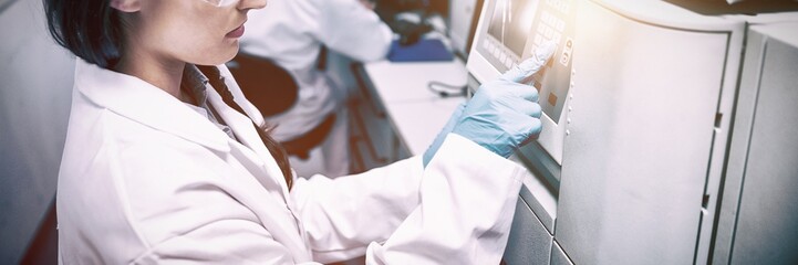 Young chemist using machine