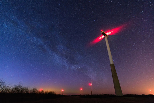 Beautifl Night Starry Sky With Milky Way Galaxy, Win Turbines And Aurora Borealis.