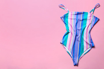 One-piece swimsuit on color background, top view