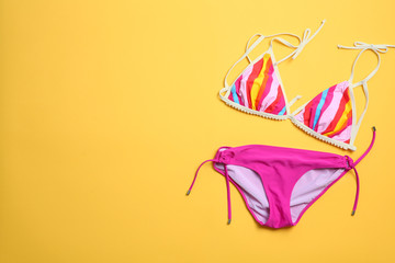 Stylish bikini on color background, top view