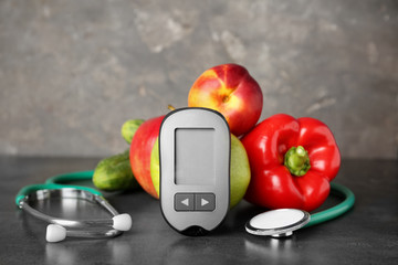 Digital glucometer, stethoscope, fruits and vegetables on table. Diabetes concept