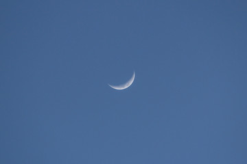 Obraz na płótnie Canvas A crescent moon in the center of blue sky