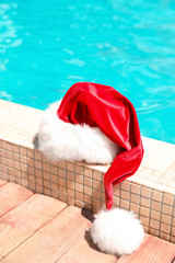 Obraz na płótnie Canvas Authentic Santa Claus hat near pool at resort
