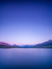 Beautiful Icelandic landscape with mountains in the background and a lake during sunrise.