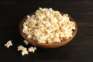 Obraz na płótnie Canvas Bowl of tasty popcorn on wooden background