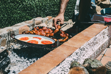 Man cooking chourizo and provolone cheese