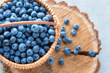 Blueberry in basket on wooden table background. Ripe and juicy fresh picked blueberries closeup, top view