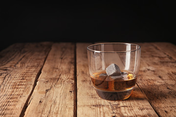 Glass with liquor and whiskey stones on table