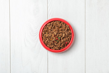 Obraz na płótnie Canvas Bowl with food for cat or dog on wooden background. Pet care