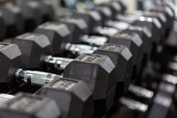 Obraz premium A row of dumbbells racked with a selective focus