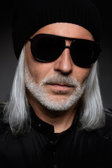 Serious bearded man wearing sunglasses. Studio shot
