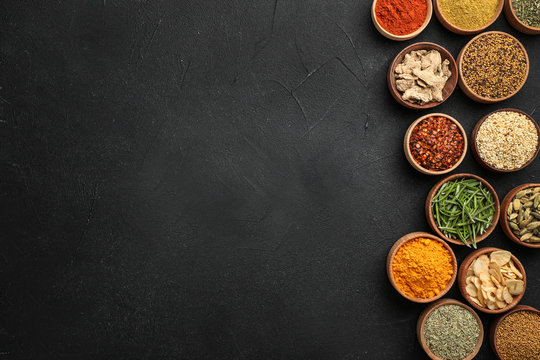 Flat lay composition with different aromatic spices on dark background