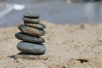 Fototapeta na wymiar Stacked Stones on the Sand at a Beach 