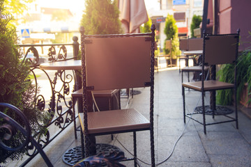 Interior of a cafe on a street on a bright summer day. Chairs and tables of a street cafe.