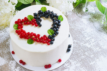 Round white cake with berries in the form of hearts, Valentine's Day, on white background. Picture for a menu or a confectionery catalog. Top view