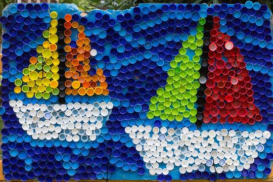 Sailboats Mosaic Deocoration Made Of Cororful Plastic Bottle Caps . Summer Season And Travel Concept. Handmade Crafts. Recycling Art.