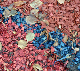 Colored mulch of colored wood chips with autumn leaves.