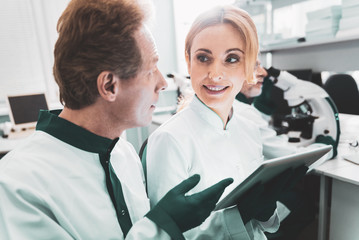 Beautiful biologist. Beautiful promising biologist looking at her professional colleague while...