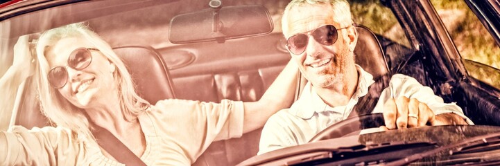 Happy mature couple in red cabriolet