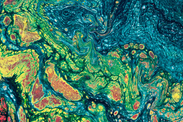 Marbling textured creative background. Mixing green, blue, yellow and red paints. Handmade surface....