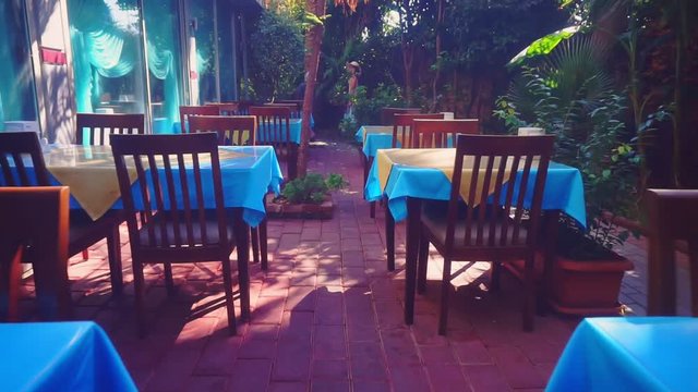 empty tables and chairs in the garden outdoors summer clear day.