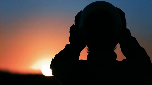 Pilot Putting On Helmet at Sunset. Mission Concept. 