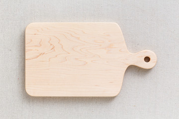 Maple handmade wood cutting board on the linen