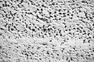 Detailed imperfect white texture of aerated foam block with holes close-up. Side of building is painted whitish. Background of construction from foamed material in macro. Decorative facing of house.