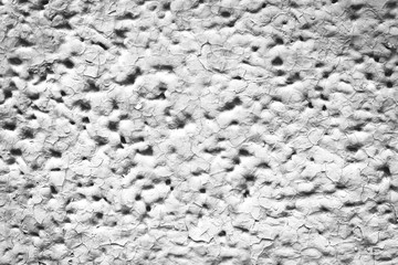 Detailed imperfect white texture of aerated foam block with holes close-up. Side of building is painted whitish. Background of construction from foamed material in macro. Decorative facing of house.