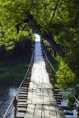 Old wooden walk hanging bridge over river