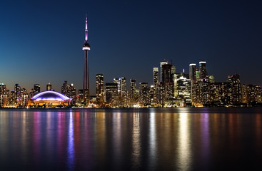 night view of a city with reflection of the lights in the water