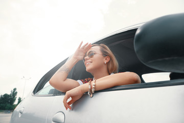 Young woman enjoying the road trip by car
