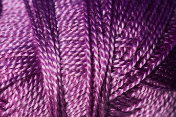 Abstract closeup of ball of purple yarn, textile material for knitting