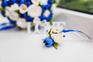 a bridal bouquet and a groom's boutonniere, on which were put wedding rings from gold