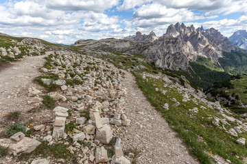 Fototapeta na wymiar Cairns near a path at the foot of the Tre Cime di Lavaredo, with Cadini di Misurina background, Dolomites, Italy