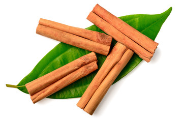 cinnamon sticks and fresh leaves isolated on the white background, top view