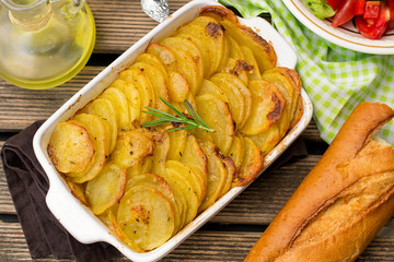 Baked crispy potato slices with rosemary served with salad