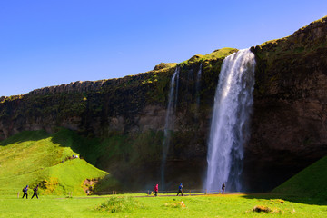 Hermosa cascada de Seljalandsfoss en Islandia con turistas